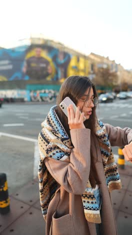 woman talking on phone in city street