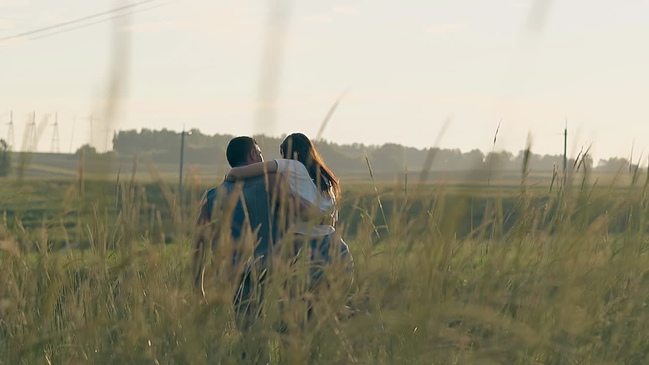 여름 드레싱을 입은 젊은 여성이 남자에 의해 들어올리고 스핀됩니다.