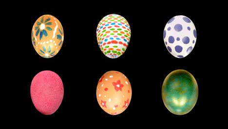 los huevos pintados de pascua girarán sobre su eje sobre un fondo aislado negro.