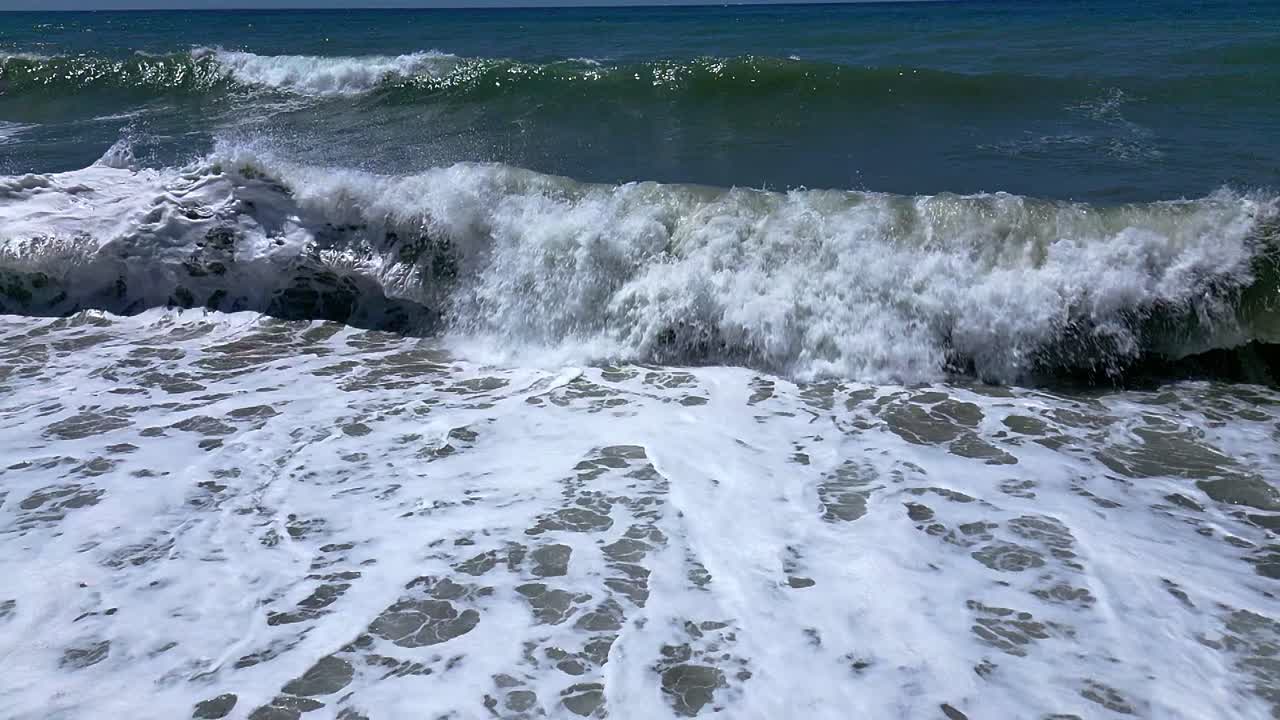 Crashing waves on the beach. Slow motion. Aerial view. Wave foam. Coastline. Andalusia. Spain.