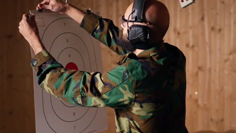 man in firing range shooting targets with pistol, wearing earmuffs