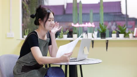 restaurant manager surfing the web and  looking over documents.