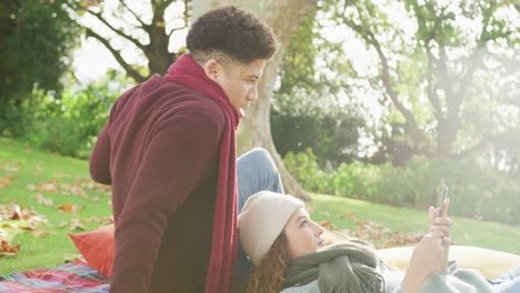 video of biracial couple warmly spending time in the garden and using smartphone