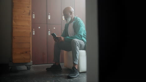 man using phone in locker room