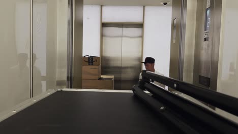 Man-moving-flight-cases-and-boxes-out-of-elevator-for-a-live-streaming-event