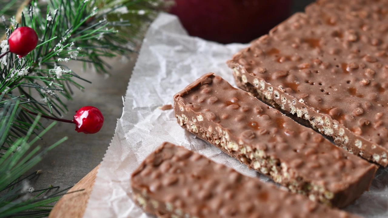 Tagliare tradizionali pezzi di delizioso torrone natalizio al cioccolato