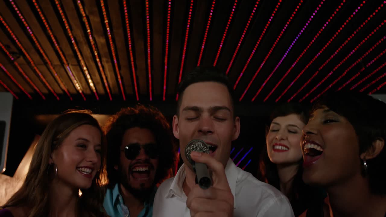 amigos felices cantando canciones juntos en el bar