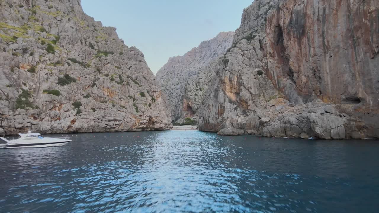 Long drone shot starting low above the mediterranean sea rising over the beach of torrent de pareis and entering the canyon of Sa Calobra, Mallorca, Spain