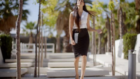 Young-businesswoman-walking-through-a-park