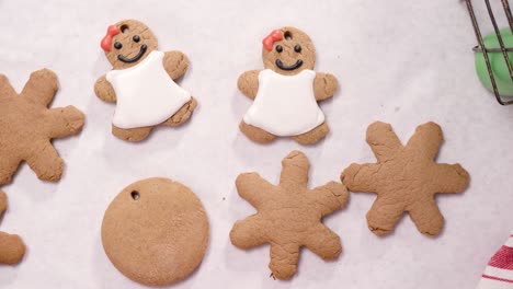 decorating gingerbread cookies with royal icing for christmas.