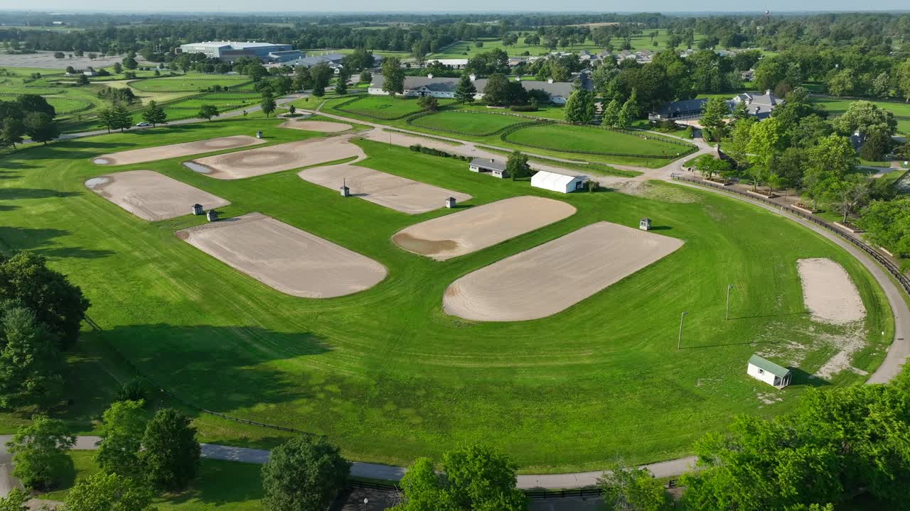 Aerial view of Kentucky Horse Park's sandy equestrian training rings amidst vibrant green fields