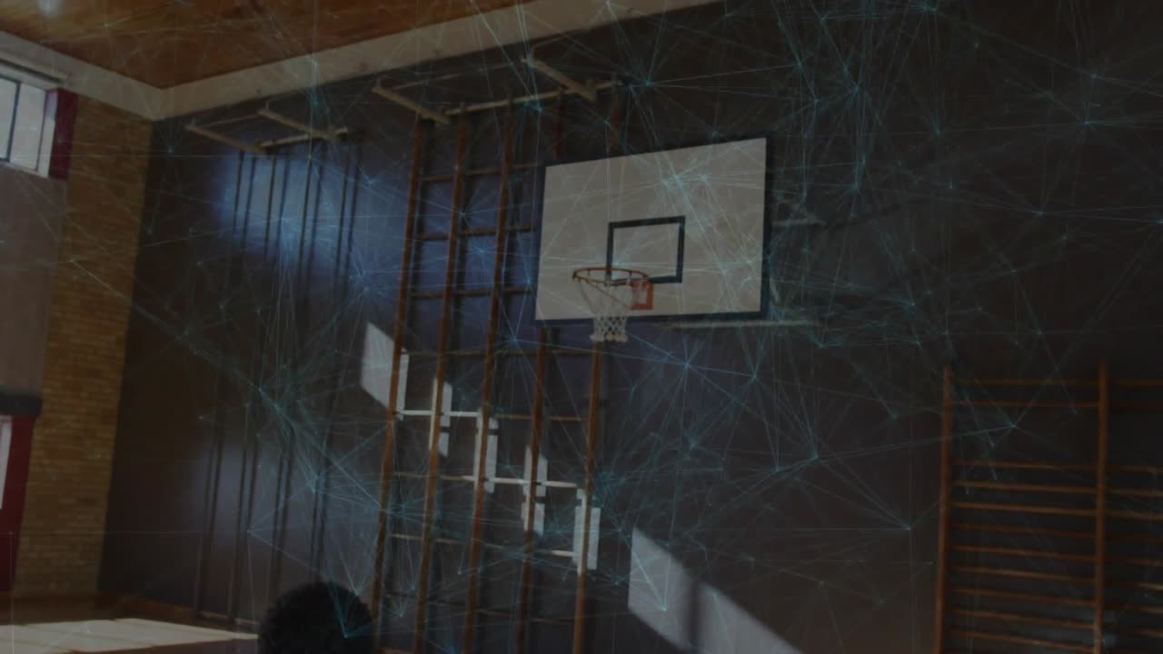 Atleta maschio che solleva una palla da basket, rilasciando la palla e praticando un tiro libero verso il canestro in una palestra sportiva