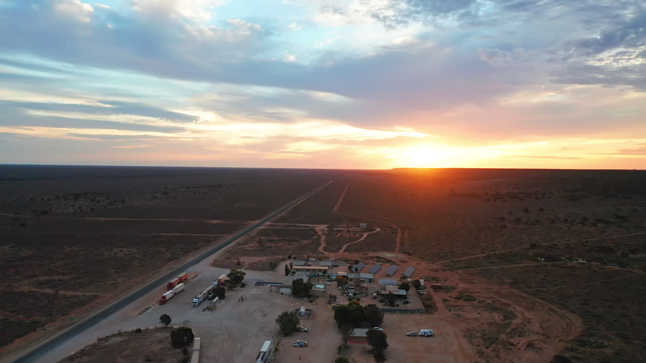 vista aérea de un roadhouse y un motel, durante la puesta de sol, en el interior de australia - reversa, disparo de drones