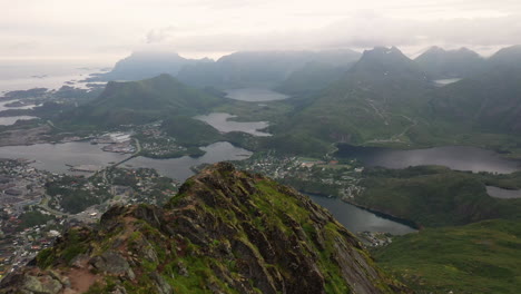 Revealing-aerial-shot-of-Svolvær-in-Lofoten,-Norway-from-mountain-top,-Fløya-and-Djevelporten-drone-footage