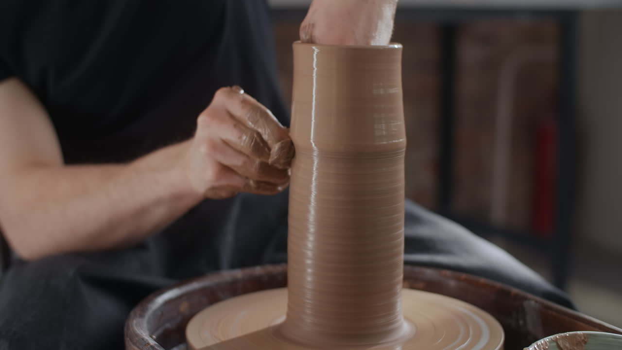 Person Shaping a Clay Vessel on a Pottery Wheel
