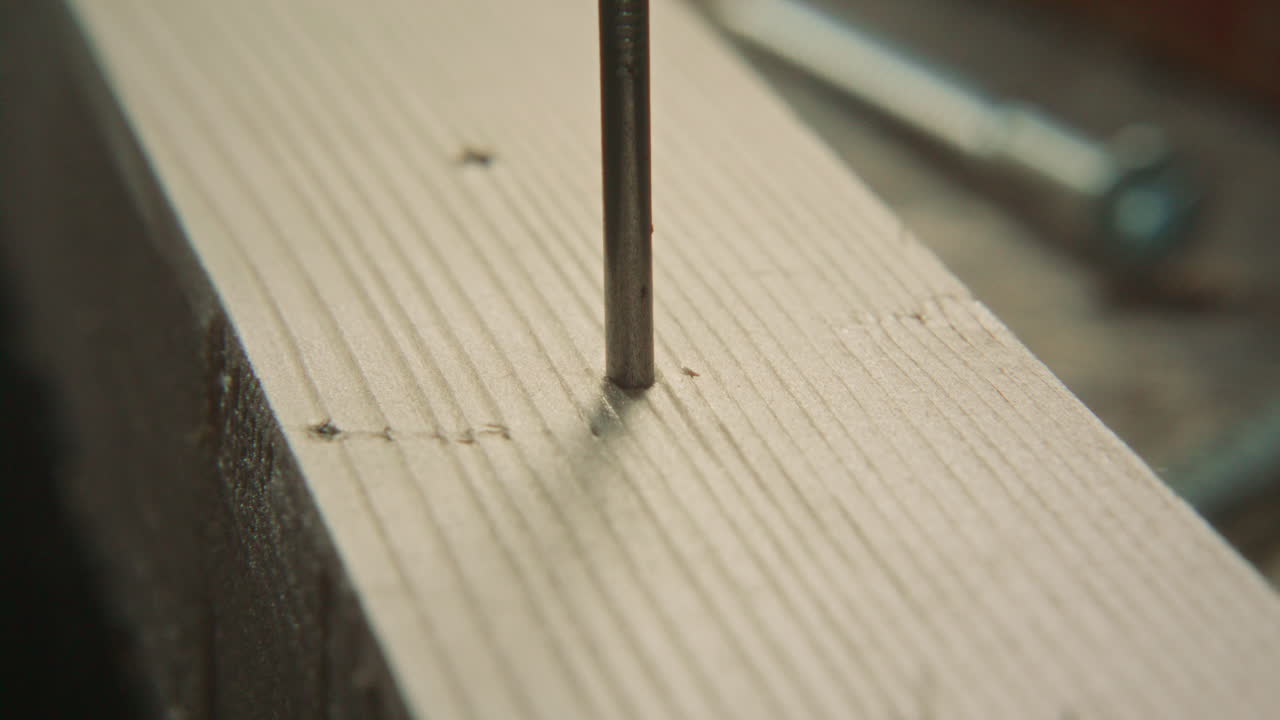 Extreme Close Up of Hammering Nail Into Wooden Plank