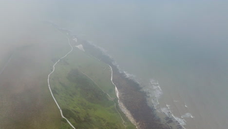 white cliffs of dover shrouded by fog and clouds in kent, england, uk. - aerial shot
