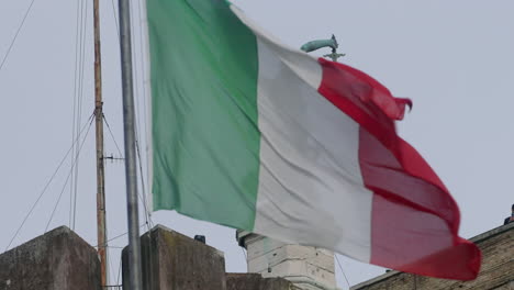 statue and waving flag at castel sant'angelo, rome, italy