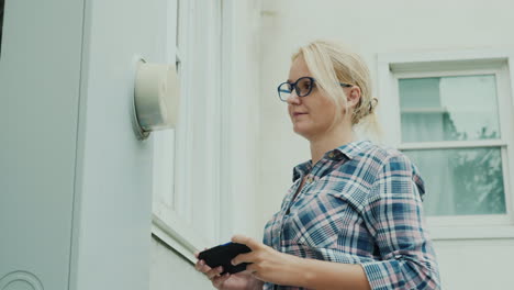 Mujer-Registra-Lecturas-De-Medidor-De-Electricidad-Utiliza-Un-Teléfono-Inteligente