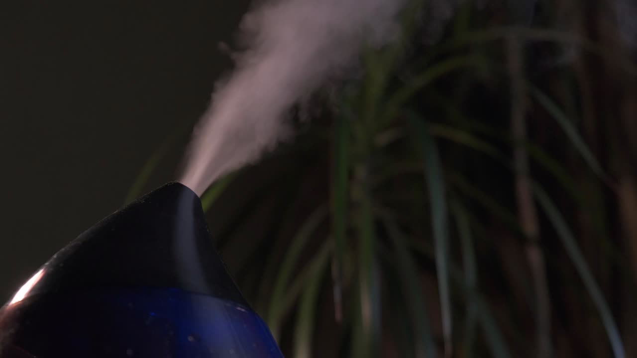 vapor de un humidificador de aire moderno en una habitación oscura.