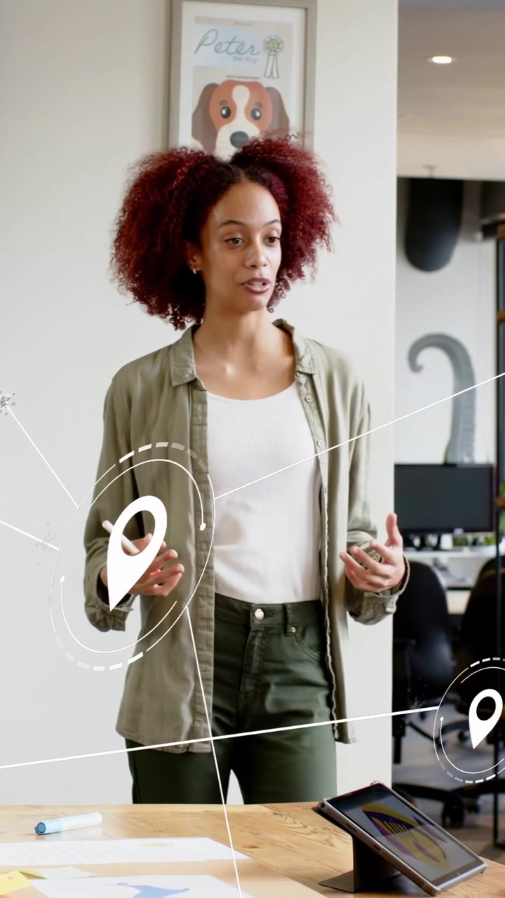 Vertical video: With marker presenter leading design pointing tablet while overlay icons sweeping