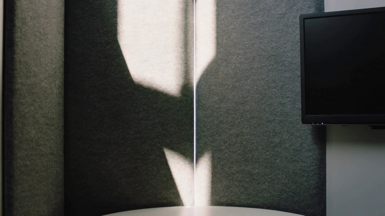 Sich verlagernde Lichtsäule tritt in die Mittelnaht ein und wirft bewegliche Flecken auf Filz in einer Kabine mit rundem Tisch