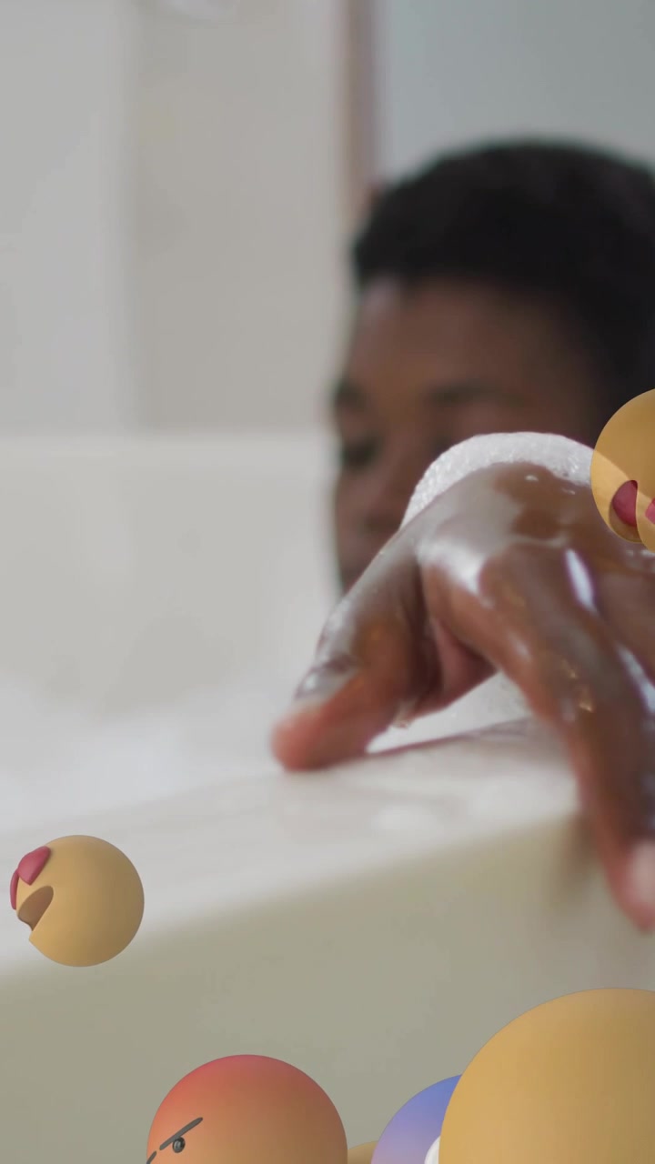 Vertical video: Woman in bubble bath reaching, emojis rising and orbiting hand for wellness