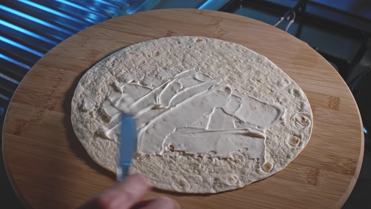 envoltura de tortilla untada con mayonesa y salsa de tomate y luego rellena con relleno de pollo y huevo