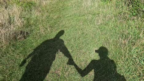shadows of a couple walking hand in hand