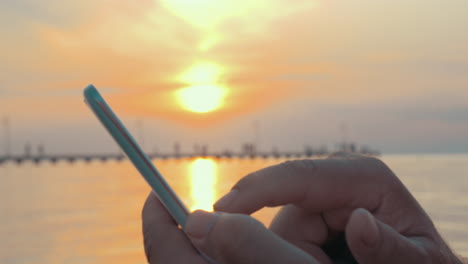 Escribiendo-En-El-Teléfono-Inteligente-Al-Atardecer