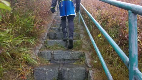 man walking in barefoot socks on wet stone steps in nature