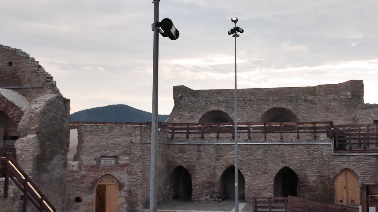 Panning view inside the Fortress of Deva in Romania, revealing the ancient stone walls, rugged textures, and remnants of medieval architecture