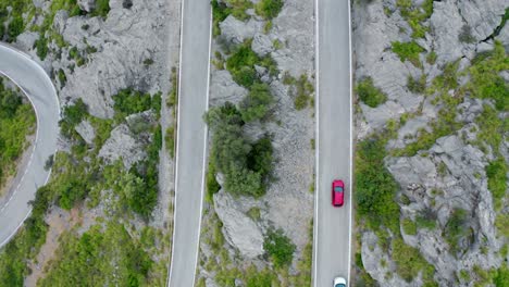 Coches-Y-Bicicletas-En-La-Carretera-A-Través-De-Una-Cordillera-Boscosa-Verde,-Vista-Aérea-De-Drones