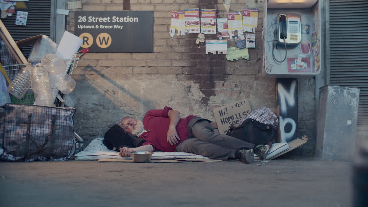 Elderly Homeless Man Sleeping on City Street beside Subway Station