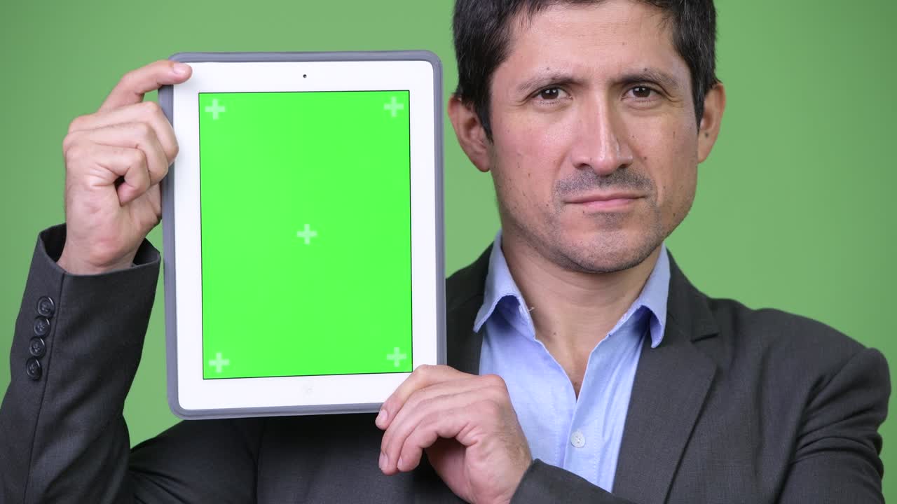 Happy Hispanic businessman showing digital tablet