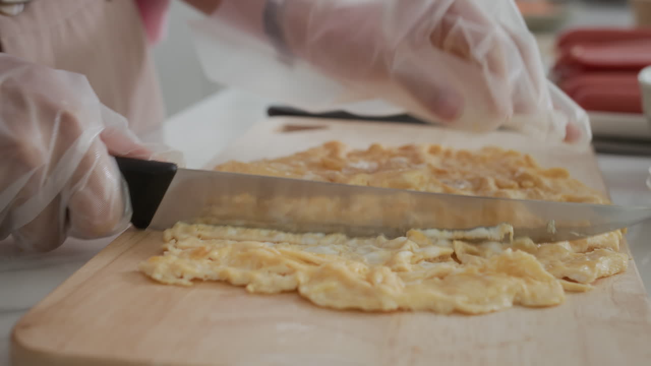 Hands of Woman Cutting Omelet at Kitchen