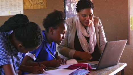 Teacher-helping-schoolchildren-in-a-lesson-at-a-township-school-4k