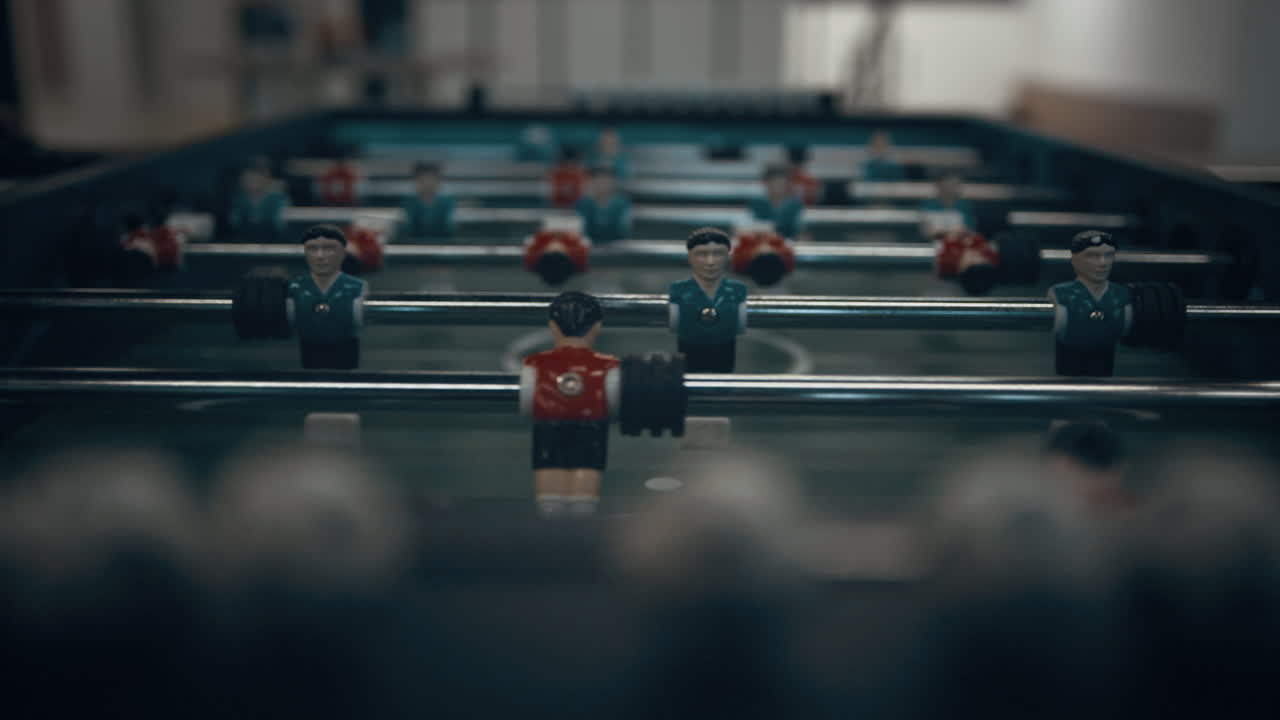 Miniature foosball players figures on table close up. Teenagers entertainment.