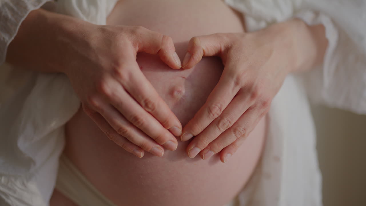 Pregnant Woman Forming Heart Shape on Belly