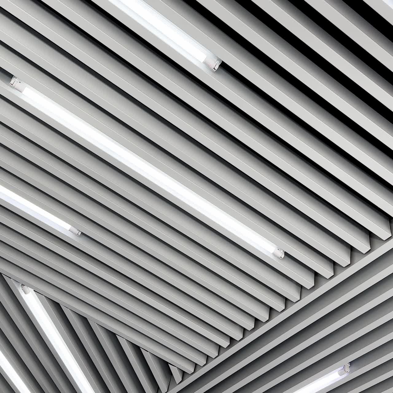 Decoration planks on the ceiling with led lamps for white day illumination. Black and white image. Low angle view