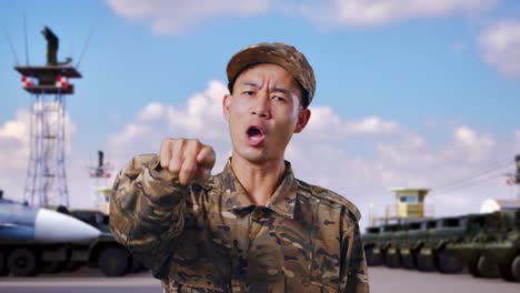 아시안 남성 군인이 군사 캠프에 서서 카메라에 소리치고 있는 장면