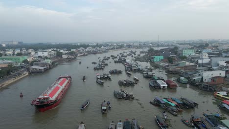 large cargo ship navigates can tho river among smaller boats, vietnam