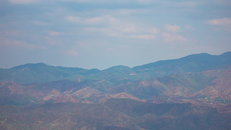 timelapse of a mountain range with clouds passing by reflecting their shadows