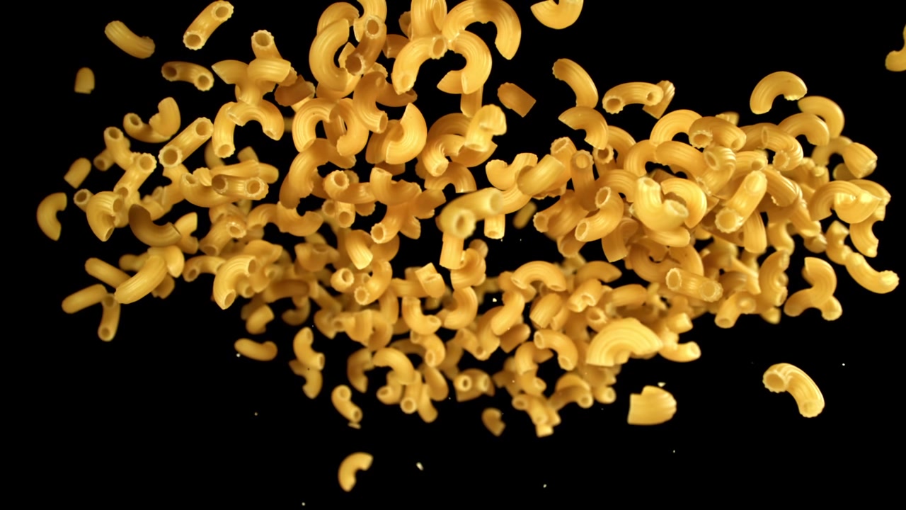Maccheroni a Gomito Secchi che Cadono al Rallentatore su Sfondo Nero