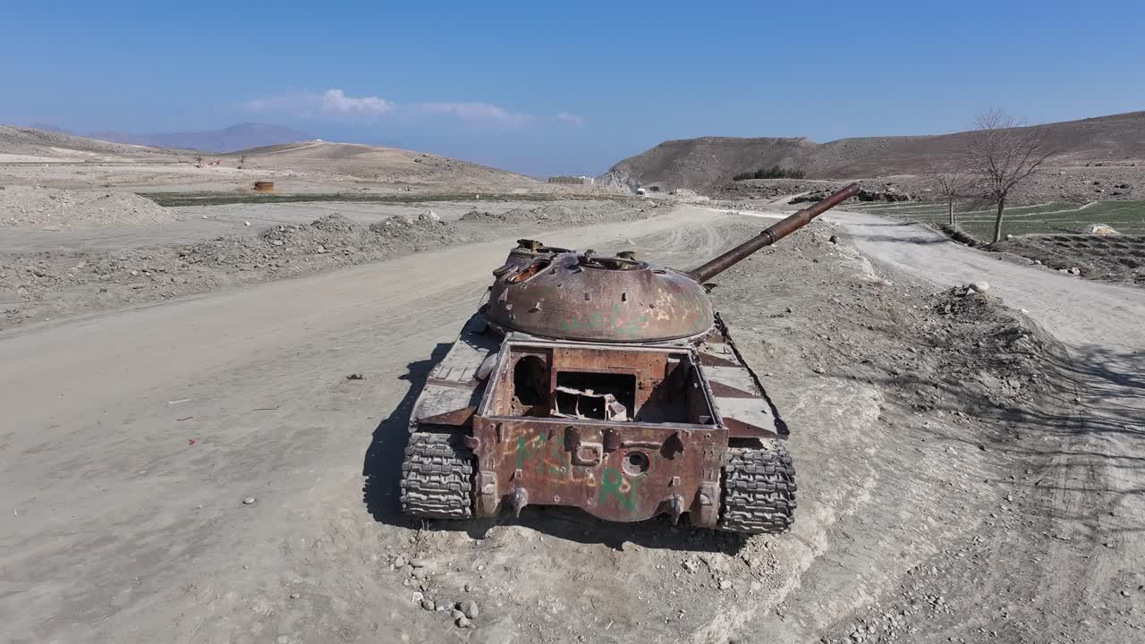 Carro armato militare sovietico T62 arrugginito e distrutto in Afghanistan, drone che lo sorvola, Nangahar, Nuristan dalla guerra sovietico-americana in un paesaggio desertico, distretto di Khogyani. Segni di un paese dilaniato dalla guerra