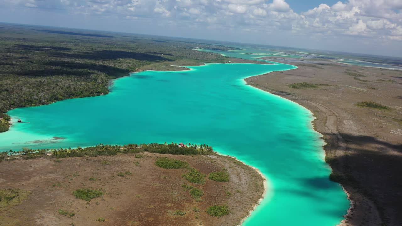 Dronefoto av Bacalar-lagunen, Mexico, som viser levende turkist vann som snor seg gjennom frodig jungel og våtmarker. Fantastisk naturlandskap som fremhever den berømte “Lagunen med syv farger.”