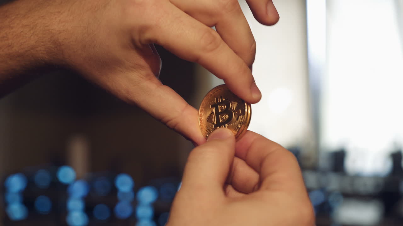 Cryptocurrency gold bitcoin coin in man hand. Symbol of crypto currency. Electronic virtual money for web banking and international network payment