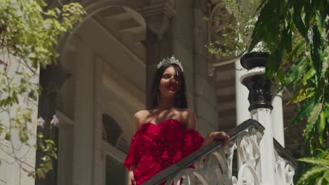 Within-the-timeless-beauty-of-a-Caribbean-castle,-a-young-woman's-red-gown-stands-out-against-the-backdrop-of-history