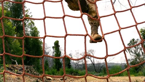 military men climbing the net during obstacle course