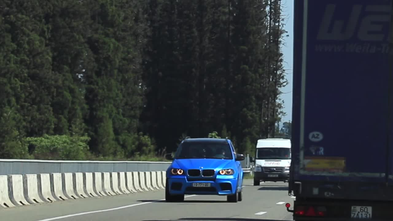 Vehicles driving on a tree-lined highway